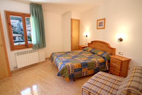 Habitación de hotel con 2 camas y sofá en Can Falera en Setcases