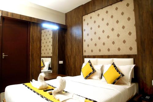 a bedroom with a large bed with two swans on it at Grand Oliver in Chennai