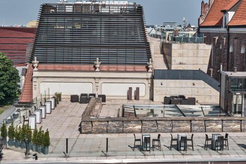 a large building with tables and chairs in front of it at Hotel Monopol in Wrocław