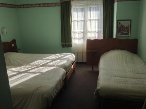 a hotel room with two beds and a window at Hôtel Restaurant Zum Schnogaloch in Obernai