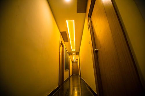 an alleyway with yellow walls and lights in a hallway at Grand Oliver in Chennai
