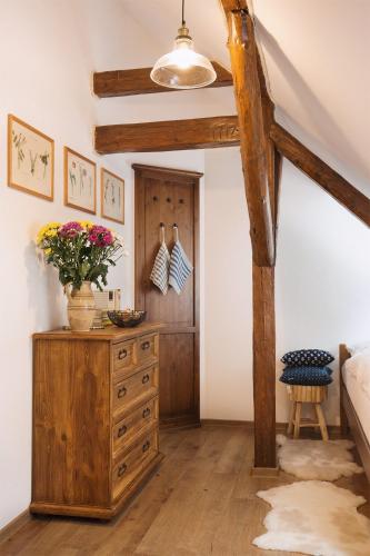 a room with a wooden dresser with a vase of flowers on it at CHATA MISTRIK in Donovaly
