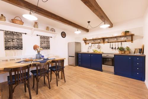 a kitchen with blue cabinets and a table and chairs at CHATA MISTRIK in Donovaly