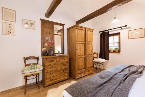a bedroom with a wooden dresser and a mirror at CHATA MISTRIK in Donovaly