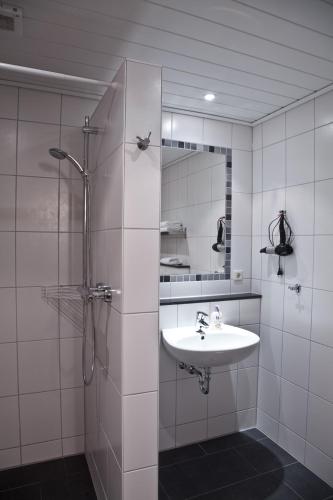 a white bathroom with a sink and a shower at Gäste und Ferienhof Maas in Dülmen