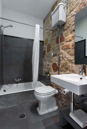 a bathroom with a white toilet and a sink at Familia in Vathi, Ithaka
