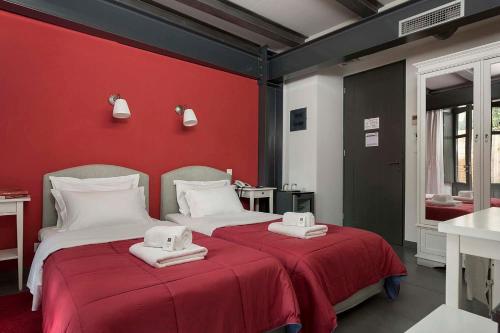 a bedroom with two beds with red walls at Familia in Vathi, Ithaka