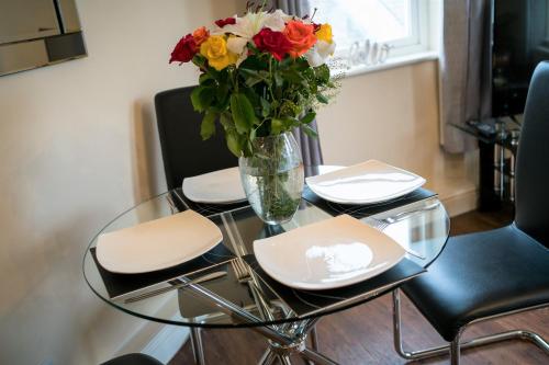 a glass table with a vase of flowers on it at Irene Court Cockermouth in Cockermouth
