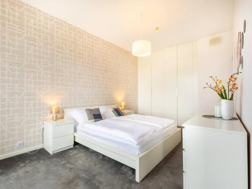 sypialnia z białym łóżkiem i 2 szafkami nocnymi w obiekcie VacationClub – Olympic Park Apartament B601 w Kołobrzegu