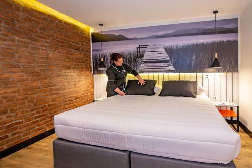 a man standing next to a bed in a room at Hostal Boutique Black Cat in Santiago