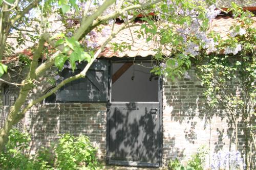 a door in a brick building with a window at B&B De Leeghpoel in Rumpt