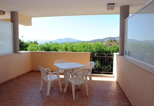 Un patio con una mesa y sillas en un balcón. en Lo Smeraldo, en Capoliveri