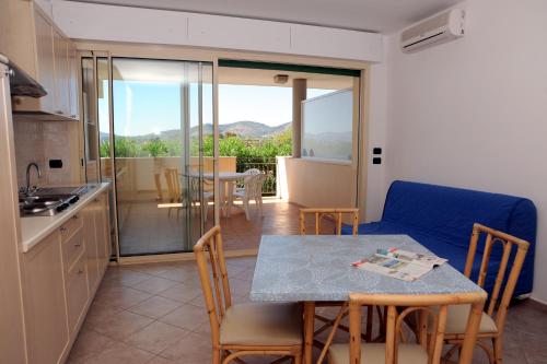 cocina y comedor con mesa y sillas en Lo Smeraldo en Capoliveri