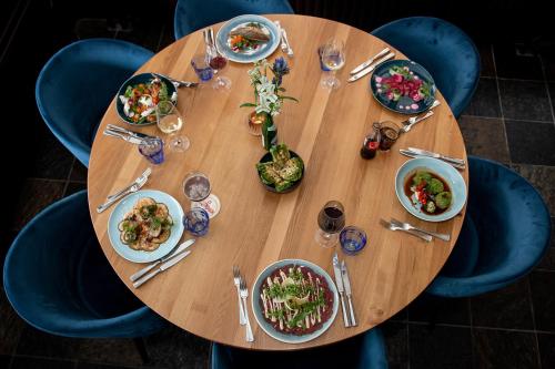a wooden table with plates of food on it at Villa-Hotel De Kroon Gennep in Gennep