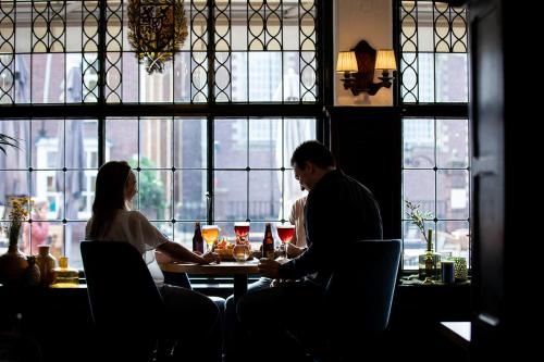 a man and woman sitting at a table in a restaurant at Hotel De Kroon Gennep in Gennep