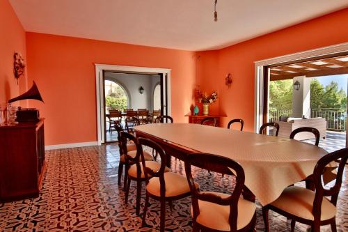 シャッカにあるVilla i Giardini di Limoni by KlabHouseのオレンジ色の壁のダイニングルーム(テーブル、椅子付)