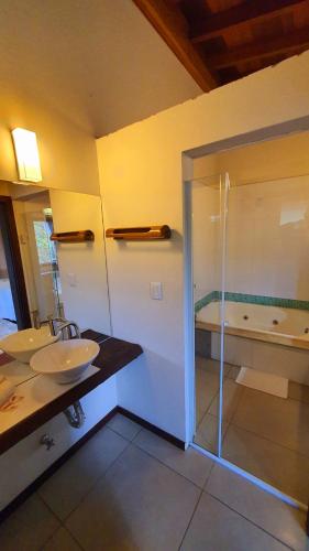 a bathroom with a shower and a sink and a tub at Pousada Paraíso Gaia in Praia do Rosa