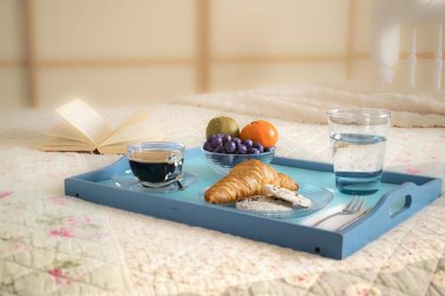 a blue tray with food and drinks on a bed at Alexandros Studios in Kalamaki