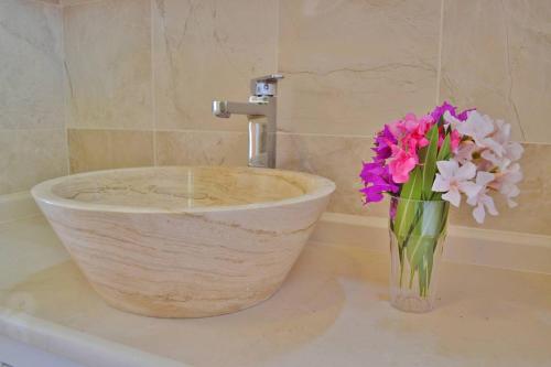 a vase of flowers sitting on a counter with a sink at Apartment Safak, LaVanta, Kalkan in Kalkan