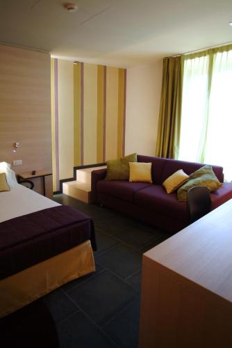 a hotel room with a bed and a couch at El Homs Palace Hotel in Comiso