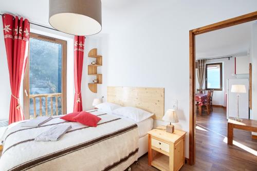 a bedroom with a bed and a large window at ETOILE LODGE in Hauteluce