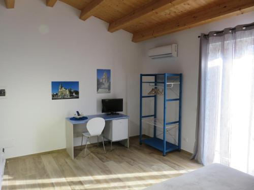 a bedroom with a desk with a computer and a chair at alex rooms in Ragusa