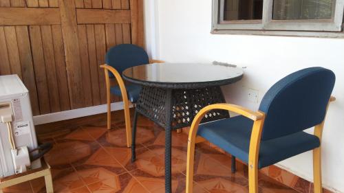 2 sillas y una mesa en una habitación en Zawadi Hotel, en Adjumani