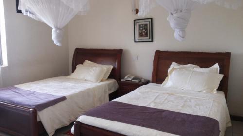 מיטה או מיטות בחדר ב-Zawadi Hotel