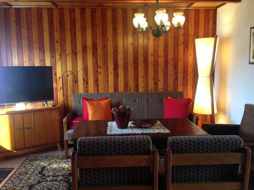 a living room with a couch and a table and a television at Försterhaus am Linowsee in Rheinsberg