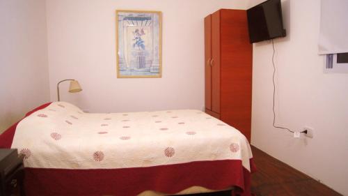 Dormitorio pequeño con cama y TV en Dpto Low Cost Terraza Alem Costanera en Gualeguaychú