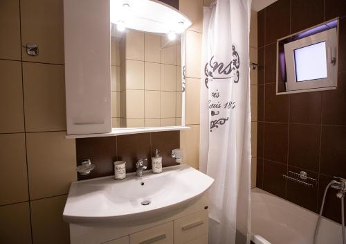 a bathroom with a sink and a shower curtain at V Luxury Apartment 1 in Ioannina