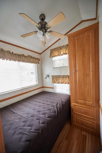 a bedroom with a bed and a ceiling fan at Bethpage Three-Bedroom Cottage 15 in Urbanna