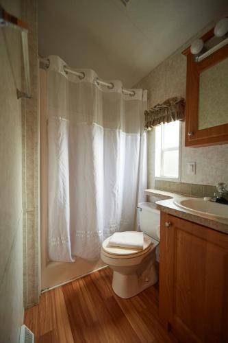 a bathroom with a white toilet and a sink at Bethpage Three-Bedroom Cottage 15 in Urbanna