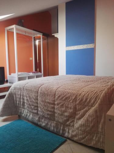 a bedroom with a bed with a mirror and a blue wall at Colle dell'Ara in Chieti