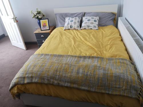 RocesterにあるNorthfield Houseのベッド1台(黄色い掛け布団、枕2つ付)