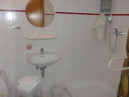 a white bathroom with a sink and a shower at Hotel & Restaurant "Zum Firstenstein" in Königshain
