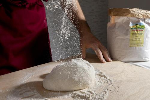 a person is mixing flour on a table at Santa Caterina Hotel & Bike in Chianciano Terme