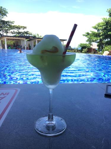 a drink in a martini glass next to a pool at Vistapaloma beach resort in Odiong