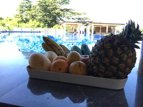 a bowl of fruit sitting on a table with a pineapple at Vistapaloma beach resort in Odiong