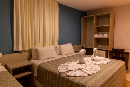 a hotel room with two swans on a bed at Pousada Mariluz in Maragogi