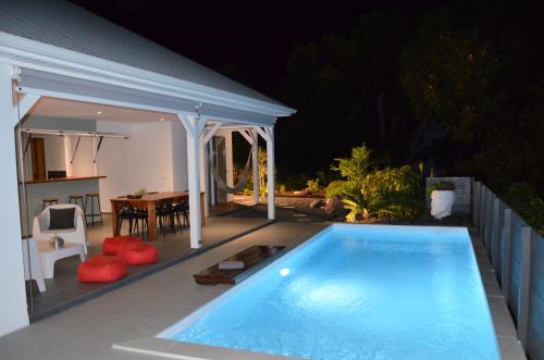 una piscina en un patio trasero por la noche en Villa Coco Cannelle en Deshaies