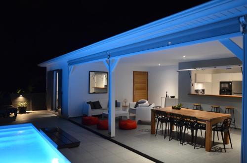 ein Wohnzimmer mit einem Esstisch und einem Pool in der Unterkunft Villa Coco Cannelle in Deshaies