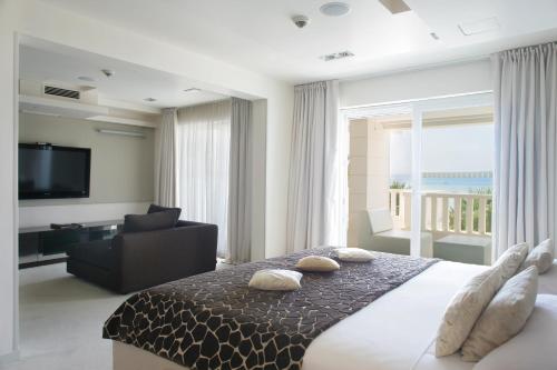 a bedroom with a bed and a couch and a television at Damianii Luxury Boutique Hotel & Spa in Omiš