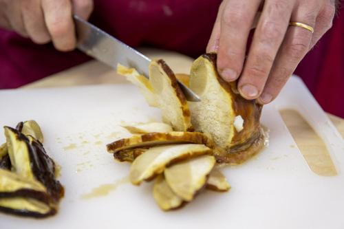 a person cutting up some food with a knife at Santa Caterina Hotel & Bike in Chianciano Terme