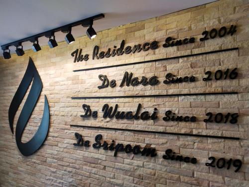 a brick wall with signs on the side of a building at Hotel De Sripoom in Chiang Mai