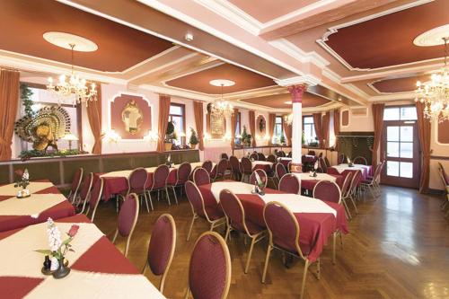 a restaurant with tables and chairs in a room at Hotel-Gasthof Zur Post in Velburg