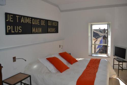 a bedroom with a bed with a sign on the wall at Appart's Village Trama Loges in Puymirol