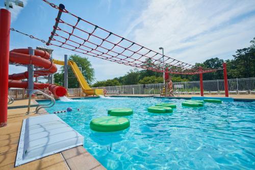 a large swimming pool with a water slide and slides at Bethpage Three-Bedroom Cottage 15 in Urbanna