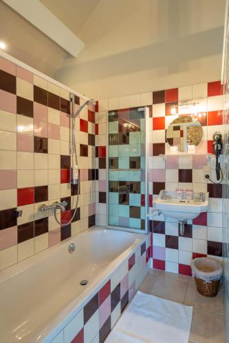 a bathroom with a tub and a sink at Gasthof Schraevenacker in Oostvleteren