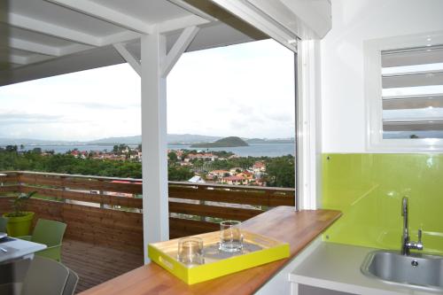 a kitchen with a view of the ocean from a balcony at LES VILLAS TARA ET ANAIS in Les Trois-Îlets